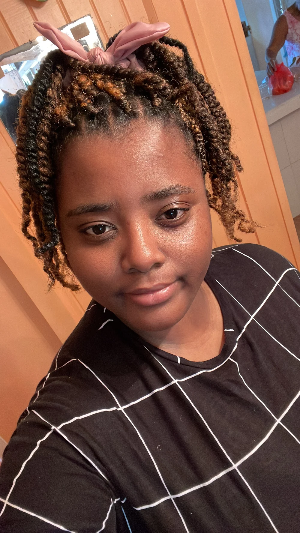 The creative behind MX App Studio, wearing a pink hair bow and a black shirt with white lines